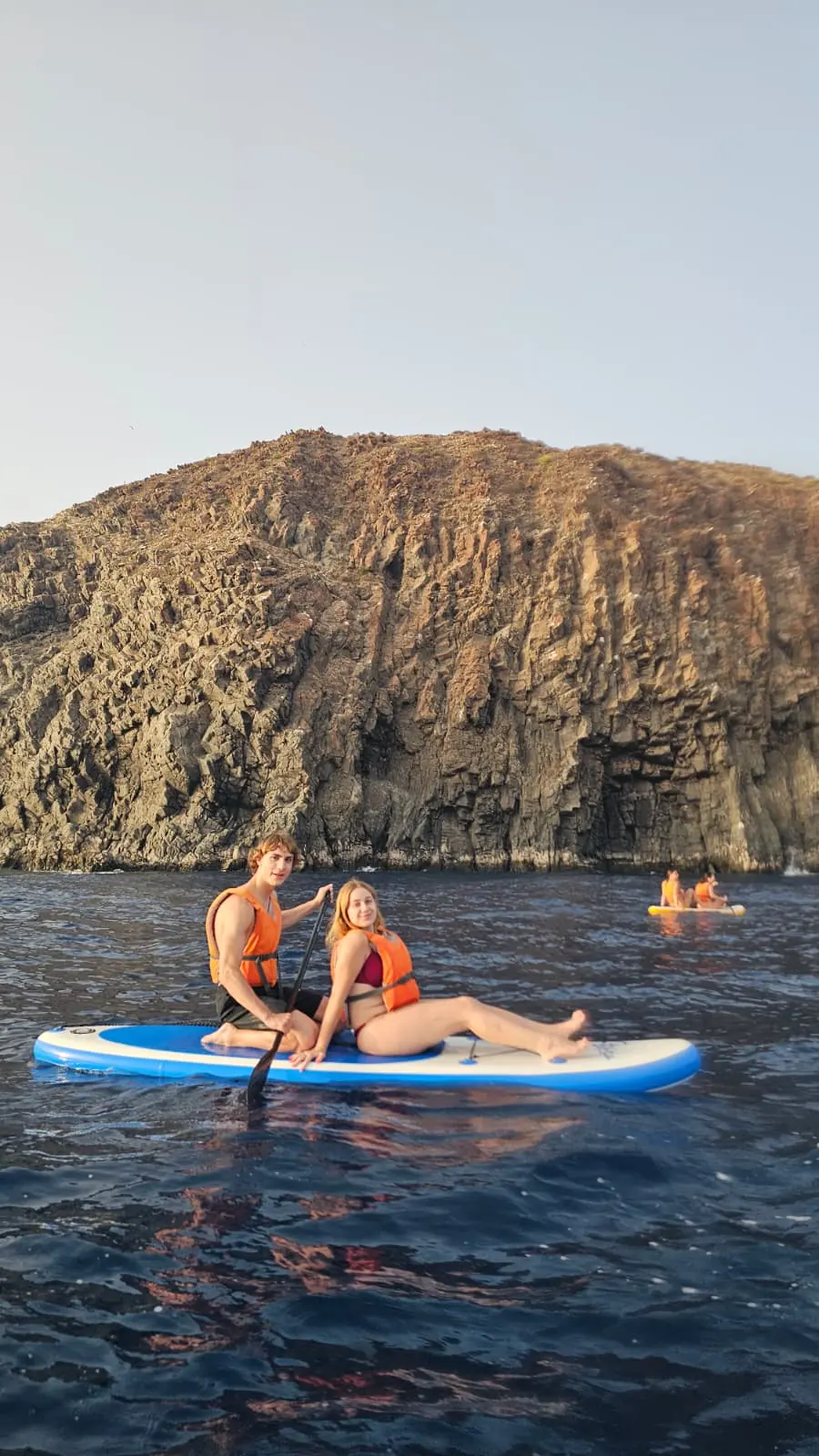 Pareja disfrutando de paddle surf junto a los acantilados de Tenerife